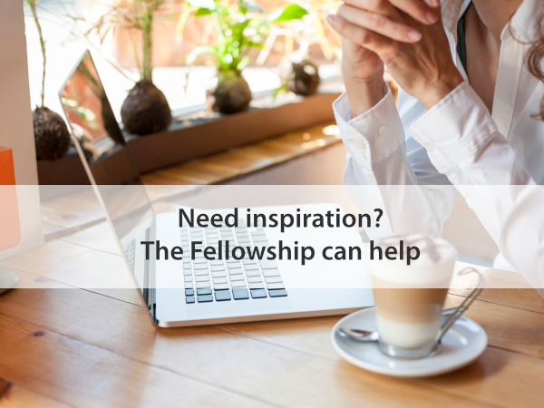 woman in front of laptop keyboard with a coffee thinking about writing